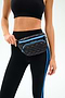 A person wears a black sports bra and black leggings with blue stripes, posing with the SPLITS59 MZW x Splits59 Small Metro Sling quilted black fanny pack strapped at the waist.