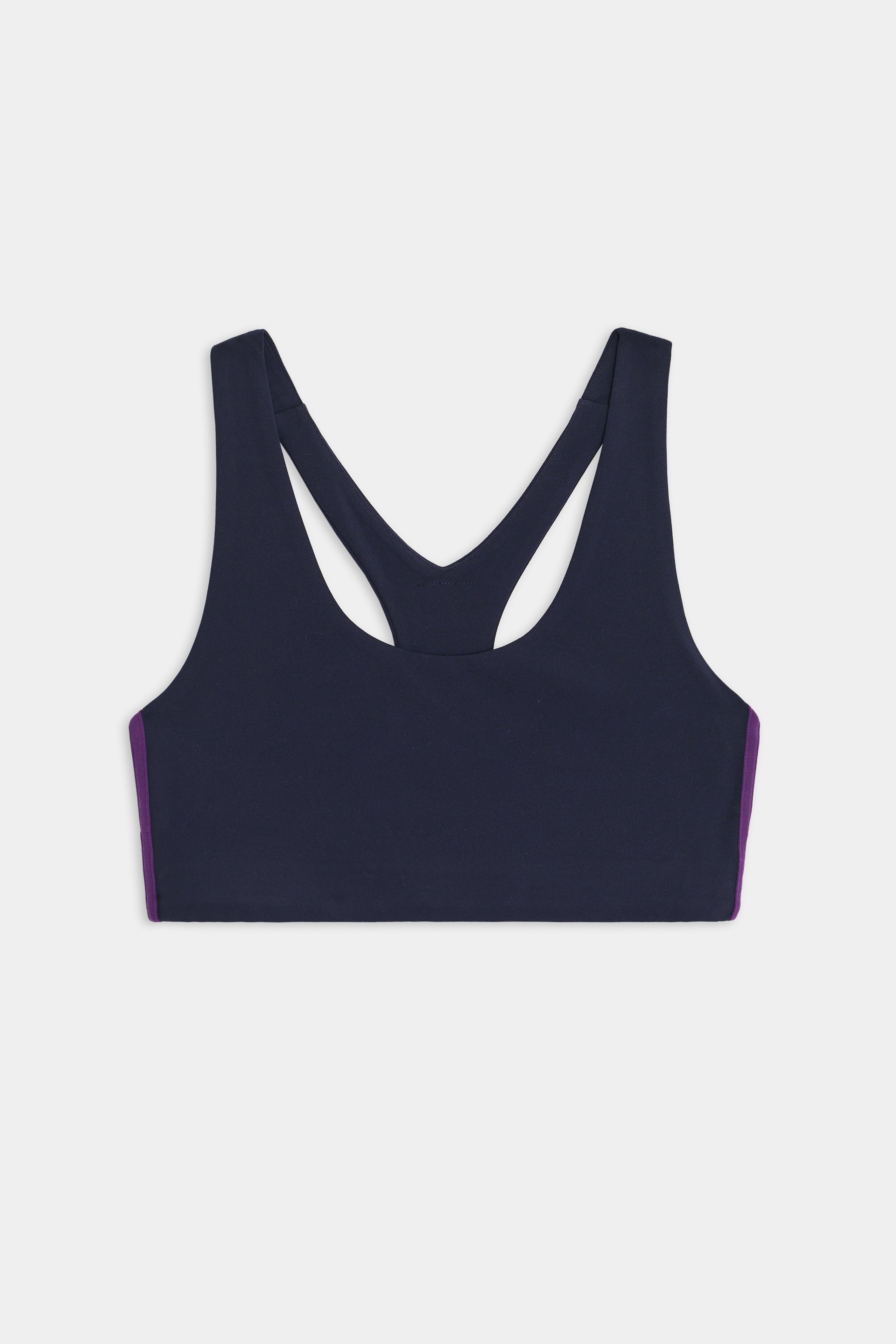 The Ella Airweight Bra by SPLITS59 features an indigo design with black currant side panels and a racerback, perfect for hot yoga. Displayed on a plain white background.