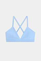 The SPLITS59 Theo Rigor Bra features a light blue shade with thin straps and a crisscross back design, showcased against a plain white background.