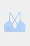 The SPLITS59 Theo Rigor Bra features a light blue shade with thin straps and a crisscross back design, showcased against a plain white background.