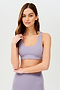 Front view of girl wearing light purple sports bra with two thin white stripes down the side and light purple leggings
