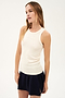A woman in a Kiki Rib Tank Full Length - Creme by SPLITS59 and black skirt, doing yoga.