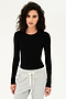 A woman wearing a SPLITS59 Loren Seamless L/S Tee in Black and grey sweatpants for yoga.
