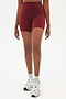 Front view of girl wearing highwaisted mid thigh deep bike shorts with white shoes
