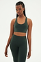 Front view of woman with black braids wearing dark green leggings and dark green bra