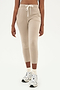 Front view of woman wearing light brown creme tone crewneck sweatshirt and sweatpant with tapered leg and above ankle length with white drawstring and side hip pockets paired with white shoes with black stripes