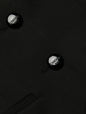 Close-up of the Ingrid Blazer Top’s black stretch suiting fabric, featuring two black LAGENCE-engraved buttons and a welt pocket at the bottom left. The image highlights the premium texture and craftsmanship of this piece.