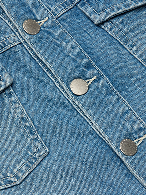 Close-up of the Kirstie Jean Shirt Jacket in blue denim, featuring three metal buttons, visible stitching, and detailed pocket and seam accents.