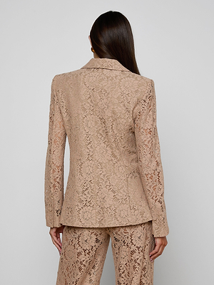 A woman with long brown hair is shown from the back, wearing the Chamberlain Lace Blazer and matching lace pants, both featuring an intricate floral lace pattern, set against a plain light gray background.