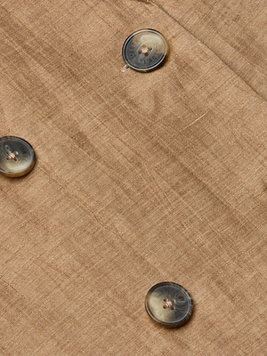 A close-up of the Colin Linen-Blend Blazer's textured light brown fabric, highlighting three round, dark-edged buttons with a subtle sheen in a diagonal double-breasted design.