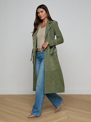 Celina wears the Celina Suede Trench Coat in olive green over a beige top, blue jeans, and beige heels, creating a timeless look perfect for any wardrobe.