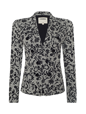 The Bethany Flocked Tweed Blazer is a women’s tailored blazer with a black and white velvet-finish floral pattern, notched lapel collar, and long sleeves. The label inside reads L’AGENCE.