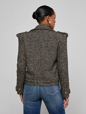 A woman with a sleek bun wears the Xoey Cropped Tweed Trench—a wool-blend jacket with shoulder pads and gold buttons—paired with blue jeans, standing with her back to the camera against a plain light background.