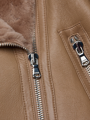Close-up of the Pike Shearling Leather Jacket, featuring brown leather, shiny metal zippers, and a soft light brown lamb shearling lining. The rich texture of the leather and gleaming hardware stand out.