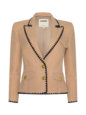 The Wylla Tweed Blazer by L'AGENCE Sale is a structured, neutral tan blazer featuring black zigzag trim on the lapels and edges, gold buttons, and a small decorative breast pocket.