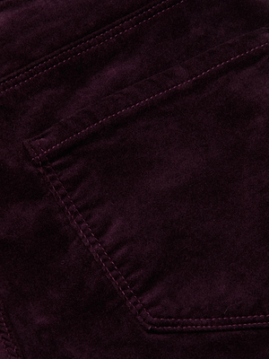 Close-up of the Stevie Velvet Jean by L'AGENCE, featuring dark purple stretch velvet corduroy, visible stitching, and an angled pocket detail.