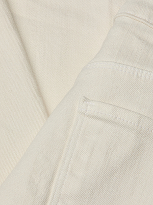Close-up of the Wanda Cropped Wide-Leg Jean in lightweight ecru denim, featuring visible stitching on the seam and pocket corner, and showcasing its soft texture.