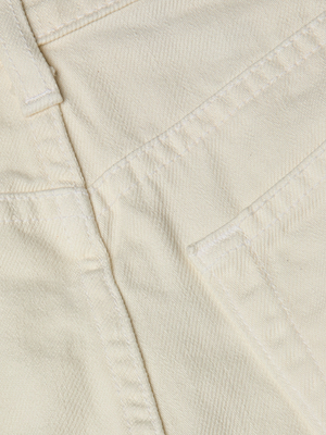 Close-up of the all-cotton denim fabric on the Clark Distressed Jean Short, showcasing detailed stitching along pocket and panel seams.