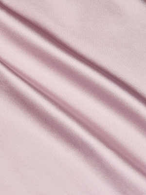 Close-up of smooth, light pink satin fabric with soft folds, evoking the luxurious feel and subtle sheen of the Perin Silk Midi Skirt.