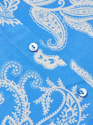 Close-up of the Holly Blouse in regatta blue fabric, featuring a cream paisley print with swirling leaves and floral motifs, plus two white buttons—perfect for a stylish long-sleeve look.