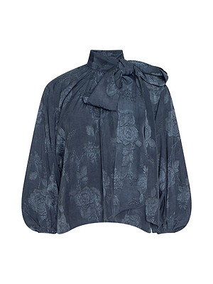 The Rhett Oversized Blouse features a dark blue floral jacquard, long loose sleeves gathered at the cuffs, a high neckline, and a large bow at the collar for an elegant, sophisticated look.