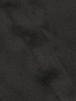 Close-up of dark gray silk charmeuse fabric with a diagonal seam, smooth texture, and subtle sheen—details featured in the Phoebe Silk Blouse, ideal for a sleeveless top or refined band collar accent.