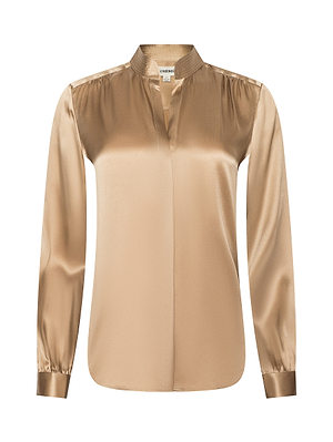 The Bianca Silk Blouse is a long-sleeved, gold silk charmeuse top featuring a band collar, gathered shoulders, a V-neckline without buttons, and a relaxed fit with a subtle sheen.