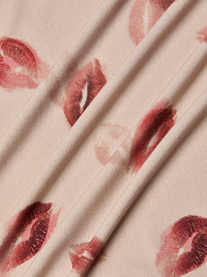 Close-up of the Ressi Fitted Tee's light beige stretch jersey knit, featuring red lipstick kiss marks and soft diagonal folds.