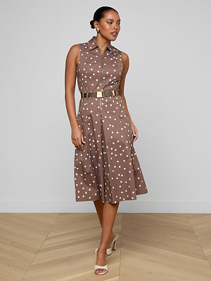 Woman wearing a brown dress with white polka dots on a plain background