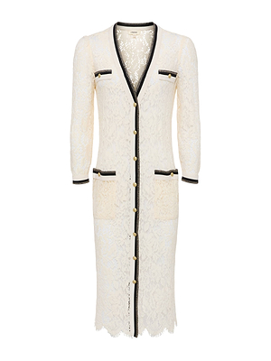 The Whisper Lace Cardigan Dress is a knee-length, long-sleeve floral lace dress with black trim, gold front buttons, scalloped edges, and four front pockets—two on the chest and two on the hips.