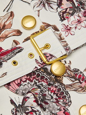 Close-up of the Ida Dress fabric belt with a gold buckle and buttons embossed with KARENJOE, showcasing a detailed butterfly jungle print in pink, brown, and white.