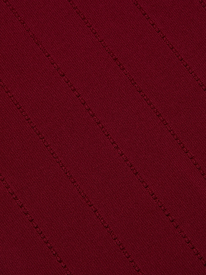 Close-up of the Gretchen Pullover by L'AGENCE, showing burgundy power knit fabric with a diagonal ribbed texture and subtle dotted lines across the surface.