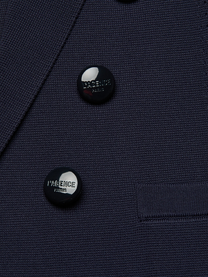 Close-up of the Mercer Knit Blazer in dark navy, featuring two shiny black L’AGENCE PARIS-engraved buttons and a partial pocket view.