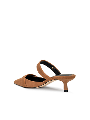 The Gilliane Heeled Mule is a tan suede mule featuring a pointed toe, mid-height kitten heel, and a single strap across the instep. This vintage-inspired shoe is shown against a white background.