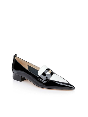 The Maelys Patent Leather Loafer is a black and white women's dress shoe with a pointed toe, low heel, and a white strap adorned with a small decorative emblem. This stylish loafer is shown on a white background.
