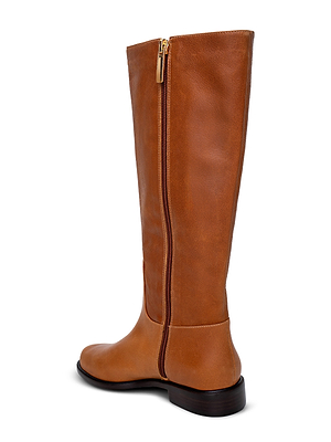 The Oceana Riding Boot is a tall, cognac leather boot featuring a gold side zipper, slight heel, and rounded toe, displayed from a rear side angle against a white background.
