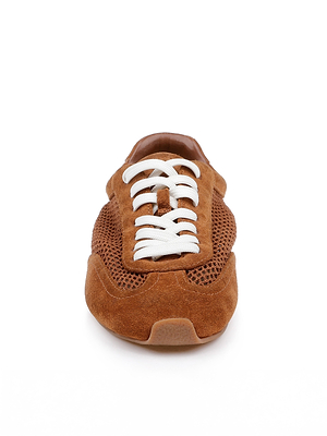 The Jarah Sneaker features a retro-inspired design in brown suede with white laces and mesh details, displayed from the front on a white background.