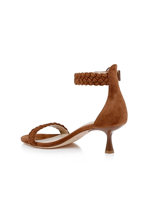 The Andelle Kitten-Heel Sandal is a brown suede heeled sandal with braided ankle and toe straps, a memory foam insole, low kitten heel, and open toe design, displayed on a white background.