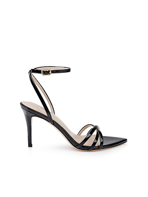 The Dua Leather Sandal, shown in profile on a white background, is crafted from black patent leather with a strappy design, thin straps, an ankle buckle, and an open toe.