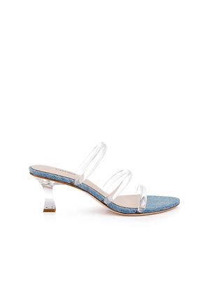 The Ludovica Kitten-Heel Sandal features three clear straps, a low curved transparent heel, and a blue denim footbed. This minimalist denim mule is shown on a white background.