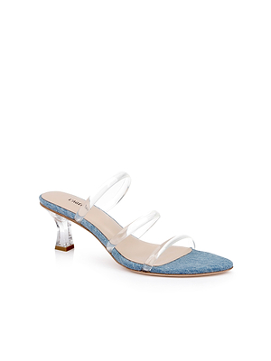 The Ludovica Kitten-Heel Sandal features a denim mule design with a low clear heel, a denim-textured sole, and three clear straps—ideal for minimalist shoe lovers. Displayed on a white background.