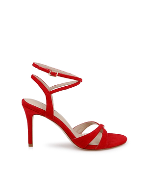 The Miranda Suede Sandal is a red suede high-heeled sandal with an ankle-wrap buckle, slim stiletto heel, and two thin crisscross toe straps—an elegant choice for evening wear.