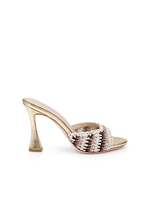 The Moyes Crochet Sandal is a gold high-heeled mule with a wide woven strap in cream, gold, and brown shades, featuring a sculpted heel, open toe, and padded memory foam insole for added comfort.