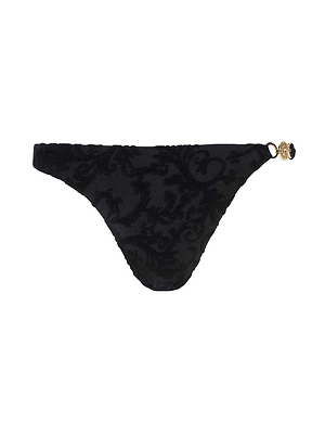 The Jean Bikini Bottom is a black velvet thong-style bikini bottom with a subtle swirling pattern, a high-leg cut, and a gold charm on one side of the waistband.