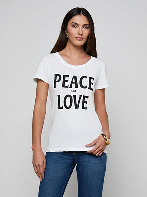 A woman with long brown hair wears the Cory Graphic Tee—a pure white cotton shirt featuring bold black 