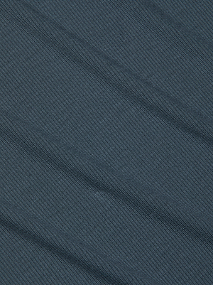 The Tess Long-Sleeve Tee by L'AGENCE is crafted from dark blue luxe microfiber with subtle diagonal ridges and faint shadowed lines, adding depth and softness to this slim-fit top.