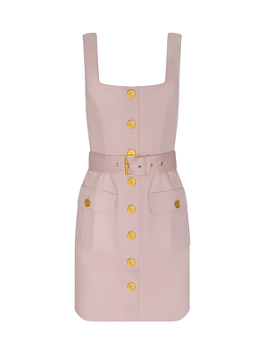 The Midy Dress is a structured cotton twill mini dress in pale pink, featuring a square neckline, gold front buttons, a matching waist belt, and two large front pockets with gold button flaps.