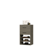 Grey closet drawer unit with slab fronts and shelves for jewelry and accessory storage.