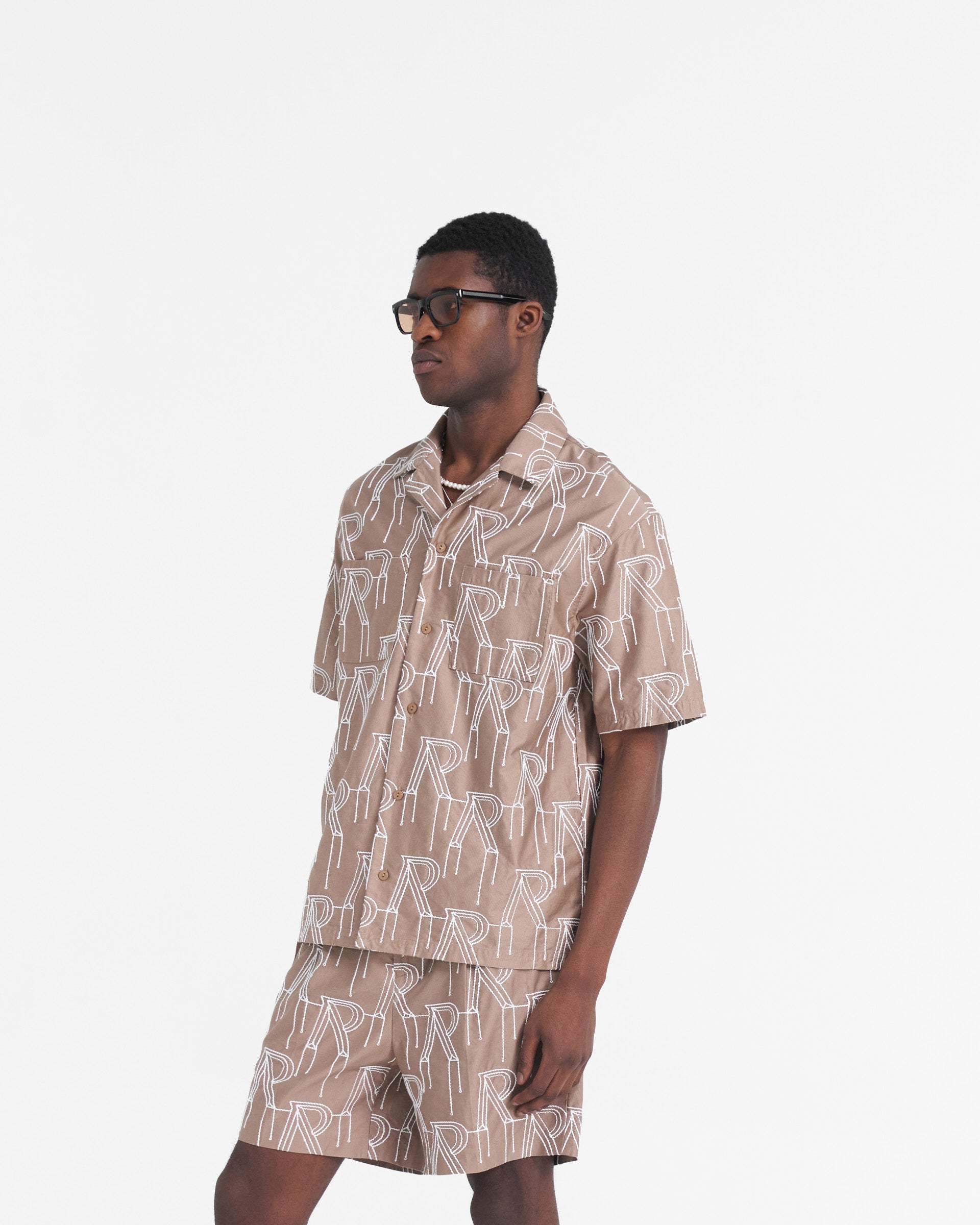 Back product image of a mens taupe shirt on a plain white background | Embroidered Initial Overshirt in Washed Taupe | Oversized short sleeved shirt with chain stitch embroidery | SS24 Shirts | Represent Clo