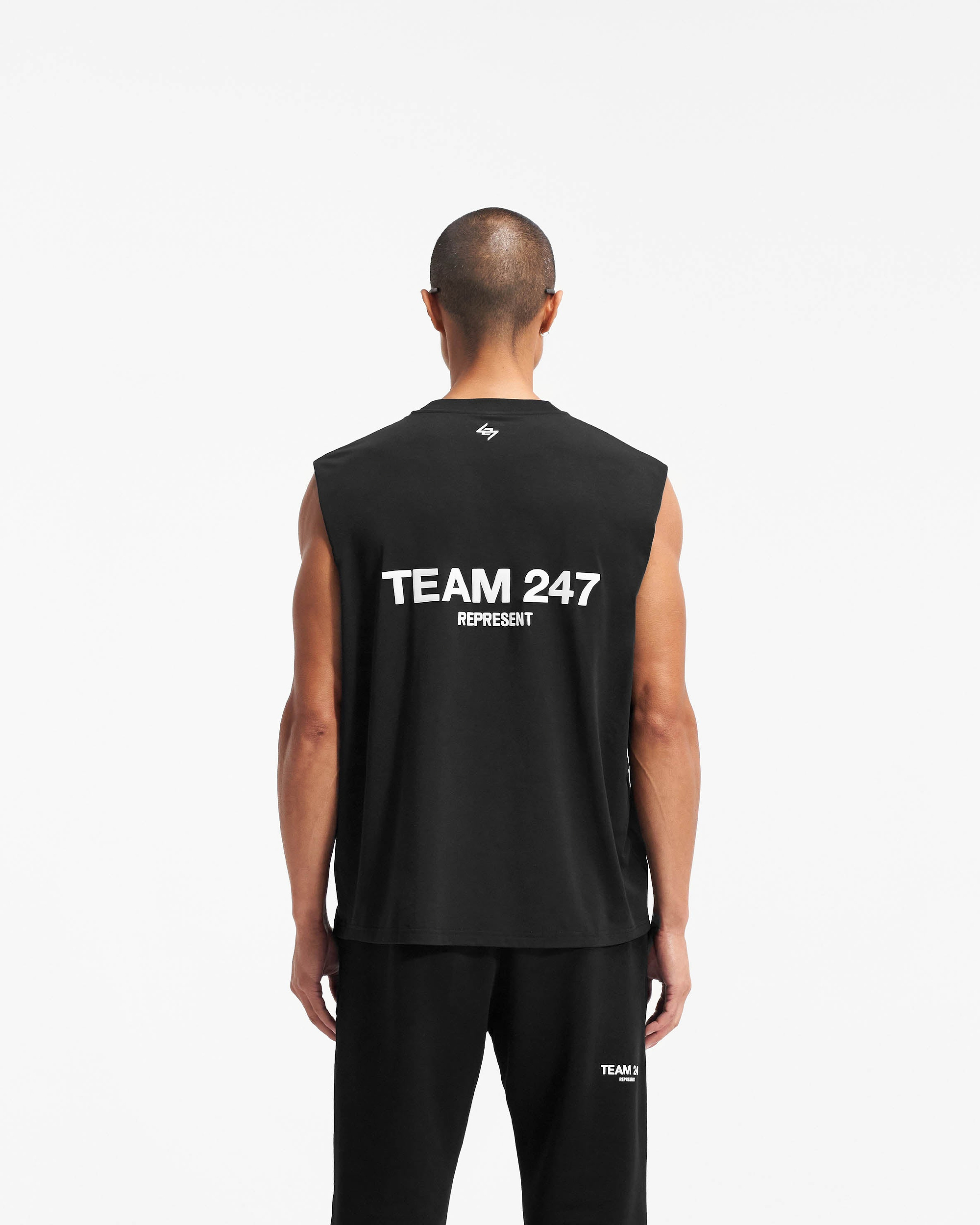 Man wearing a black tank top on a plain white background | Team 247 Oversized Tank in Black | Lightweight breathable oversized tank | 247 T-Shirts | Represent Clo